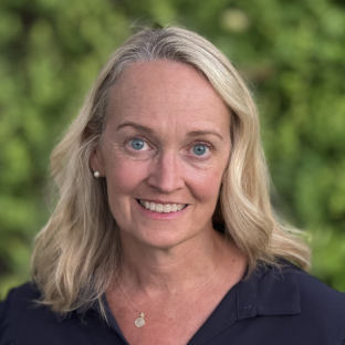 Headshot of UCLA professor Dr. Julie Elginer. She has long wavy blonde hair and is wearing a navy top.