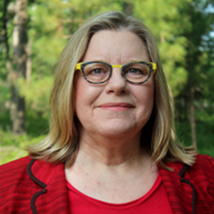 UCLA Professor Sandra Potthoff standing outdoors in red blazer and top