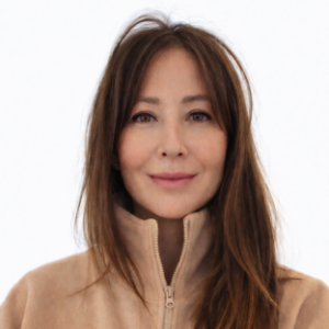 headshot of UCLA Executive MPH faculty member Dr. Sophie Snyder. She is wearing a light beige zip-up sweater. She has long straight brown hair hanging over her left shoulder.