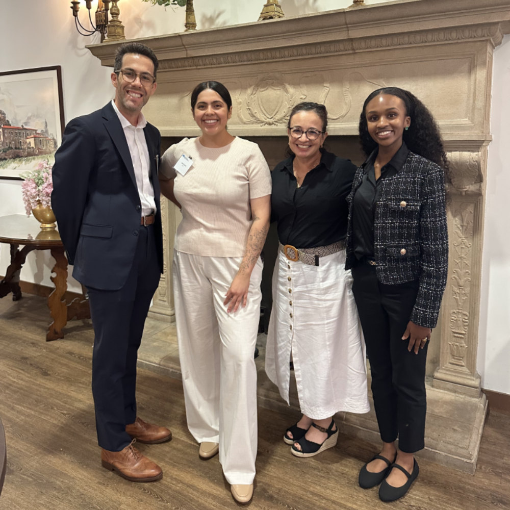UCLA Fielding School of Public Health Executive Master of Public Health students Blake Owens, Lauren Garcia, and Joelle Ragland stand with UCLA Professor Yvette Holguin at EMPH Orientation on the UCLA campus, in Mira Hershey Hall.