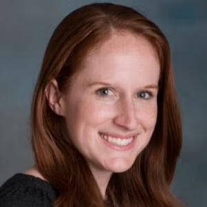 headshot of UCLA Biostatistics lecturer in the UCLA EMPH program. She is smiling and has long straight red hair and wear a black shirt.