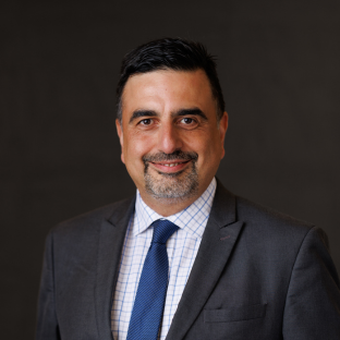 Headshot of Kaveh Houshmand Azad, EdD, UCLA Executive MPH Faculty. He is wearing a grey suit, blue tie, white checkered shirt.