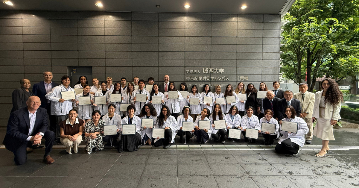 A group photo of graduates of the COPE Health Scholars Japan International Health Scholar Intensive. Each student holds their certificate of completion.