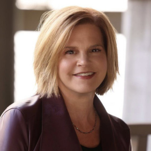 headshot of UCLA Executive MPH faculty member Jennifer Fagen. She has short straight blond hair and is wearing a burgundy colored top